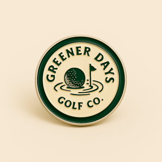 Round enamel golf ball marker with Greener Days Golf Co. branding, featuring green edge, golf ball, and flag illustration – golf accessory for putting greens.
